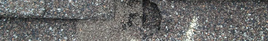 Close up of hail damage on asphalt roofing showing what hail damage looks like