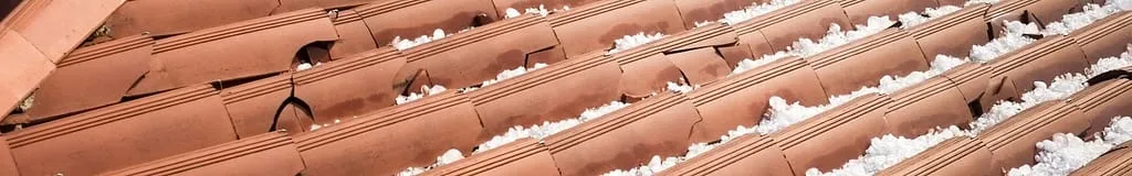Close up of broken clay tiles from hail damage on a roof